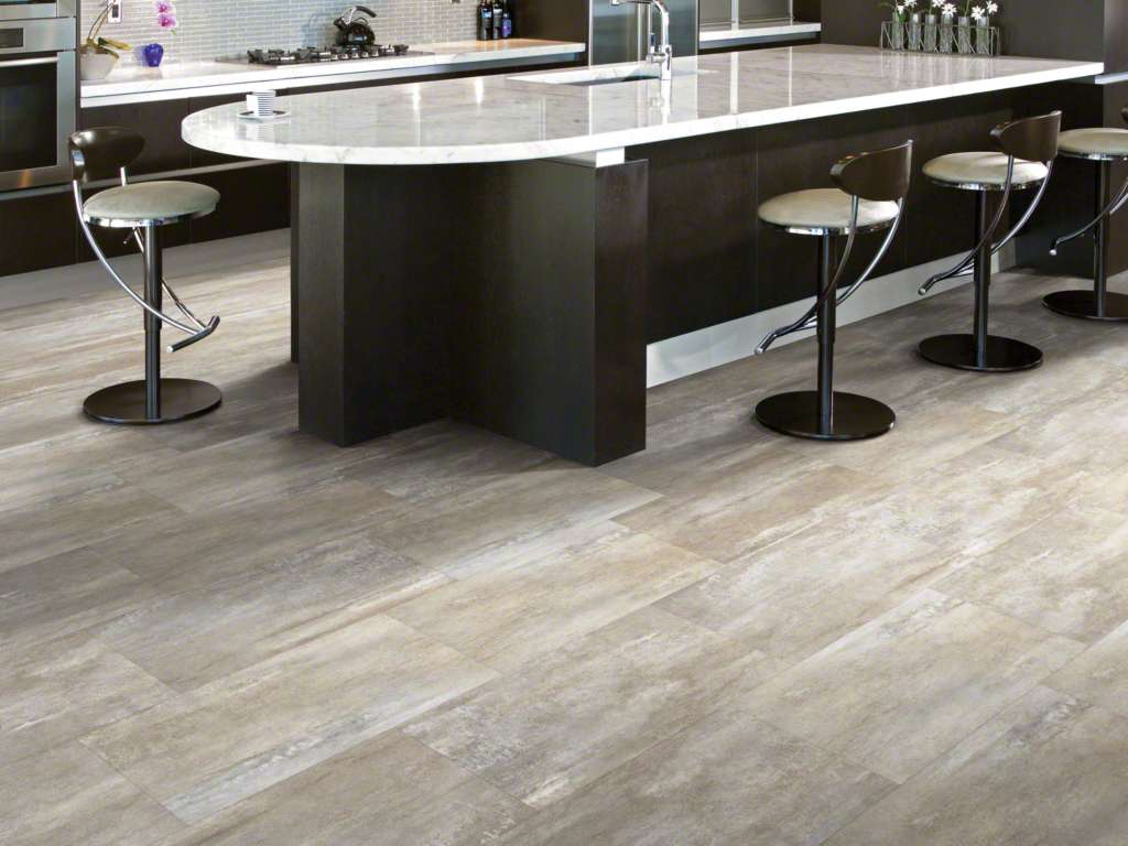 Kitchen island with bar stools over gray wood-look vinyl plank flooring